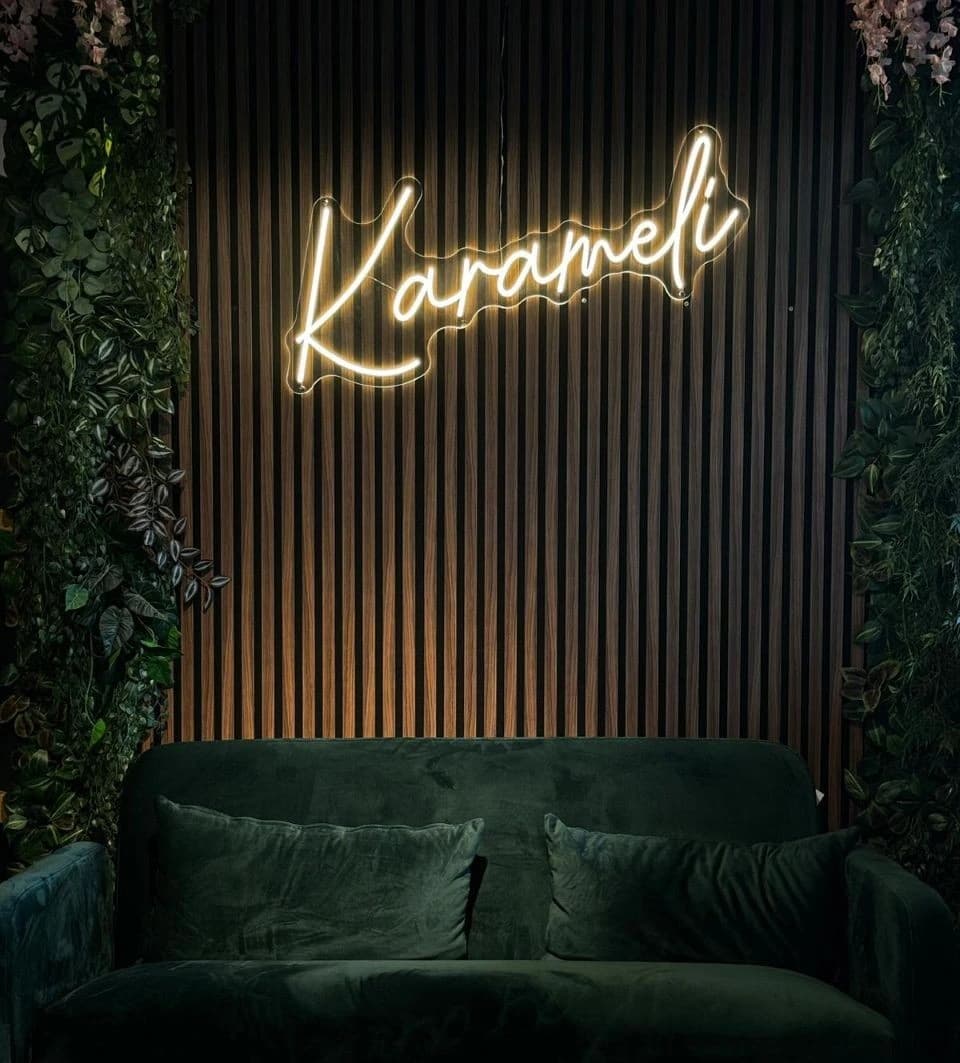 The Karameli lounge with its illuminated sign and green sofa